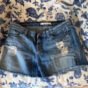 Blue Jean shorts, ripped legs and back pocket, frilled ends